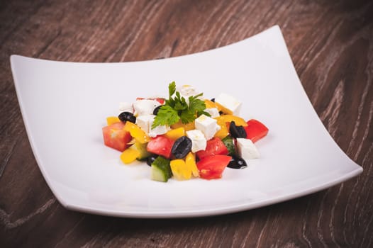 vegetarian greek salad served on white plate 