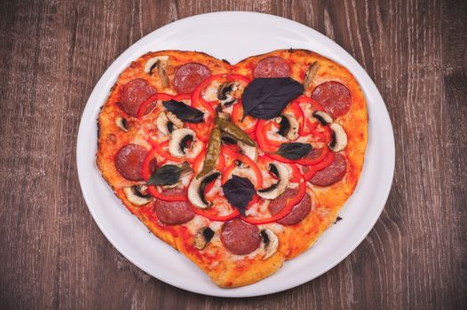 italian heart shaped pizza on white plate 