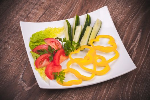 cut tomato, cucumber and bell peper,  on white plate 