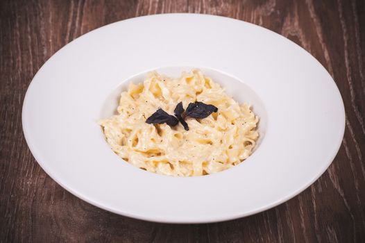 cream sauce pasta served in white plate 