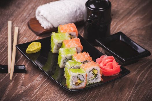 pranw and salmon sushi roll on black plate 