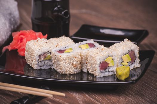 salmon tuna outside sushi roll on black plate 