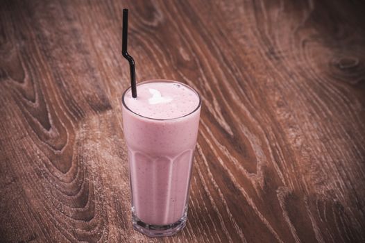 pink milk shake in glass with straw 