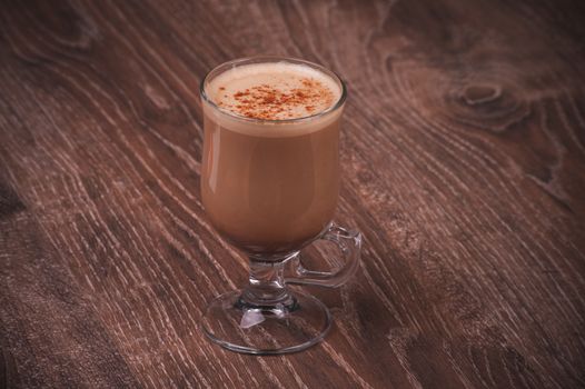 hot cacao drink in glass with milk foam