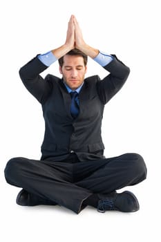 Calm businessman sitting in lotus pose with hands together on white background