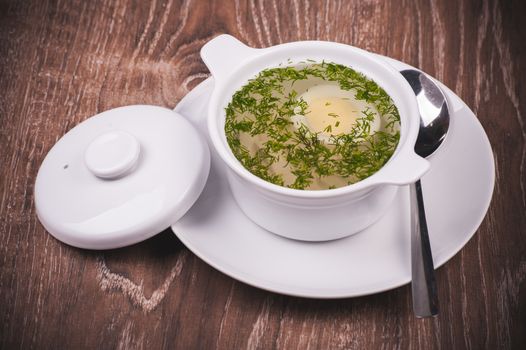 Chicken noodle soup in white plate with egg