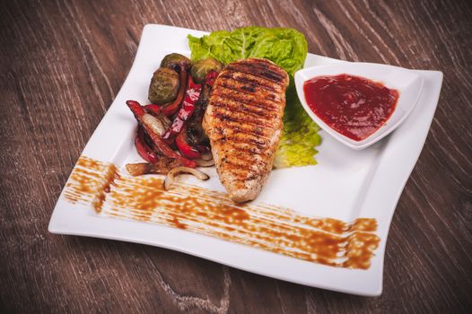 Grilled fillet of chicken with vegetables and sauce 