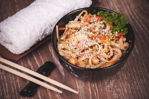 chicken udon noodles in bowl with chopsticks 