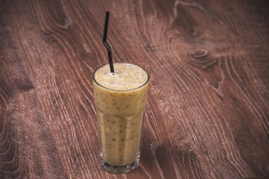 kiwi and banana  smoothie in glass with straw 