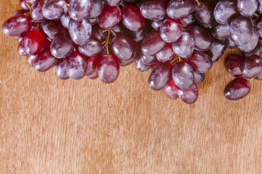 bunch or red grapes on a wood surface