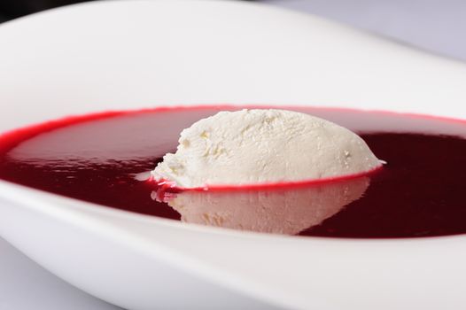 Portion of cold raspberry soup with mascarpone