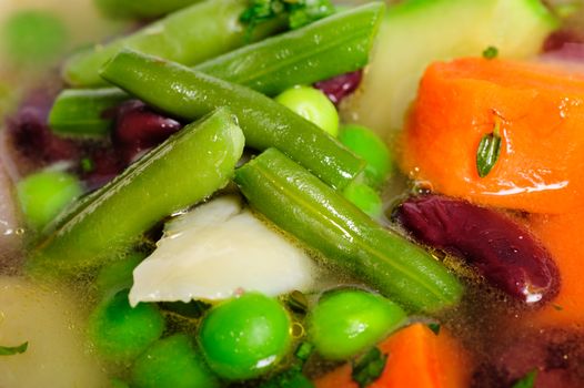 Fresh vegetable soup made of green bean, carrot, potato, red bell pepper, tomato in bowl