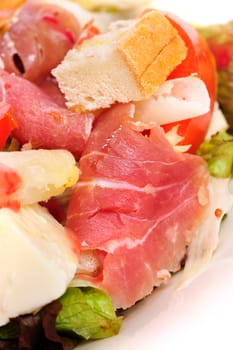 Salad with fresh vegetables, prosciutto and parmiggiano