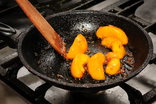 process of frying mango in big black pan