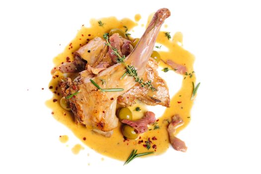 Preppared rabbit legs with ham, yellow sauce, green olives and rosemary