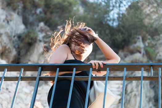 Woman looks over the railing on windy day