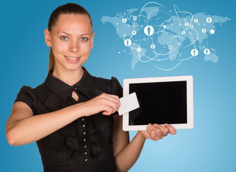 Beautiful businesswoman holding blank tablet PC and blank business card in front of PC screen. Network with people icons and world map as backdrop