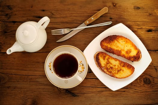 Two white toasts on white plate with cup of black tea horizontal