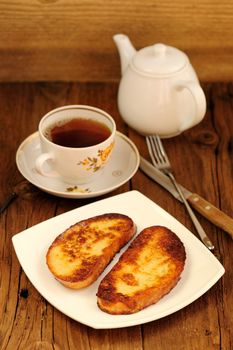 Two white toasts on white plate with cup of black tea vertical