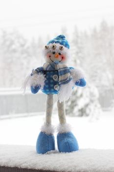 toy snowman in the street in winter clothes