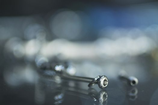 Closeup macro photo of traumatology orthopedic surgery implant metal screw set against blue out of focus background. 