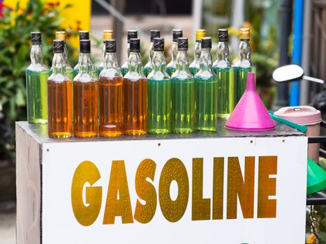 Gasoline for motorbikes sold from whisky bottles by a roadside vendor in Thailand
