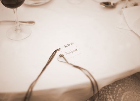 Wedding Table nametag The Bride and The Groom names and glass of red wine. 