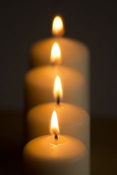 Candles burning giving off light close-up macro photo on plain background with copy space. 