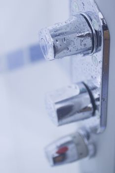 Domestic bathroom shower on off hot cold controls close-up photo with shallow depth of focus. 