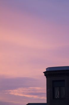 City building roof in silhouette against blue purple dusk sunset sky in Madrid Spain. 
