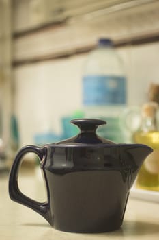 Teapot on domestic home kitchen bench with background defocused. 