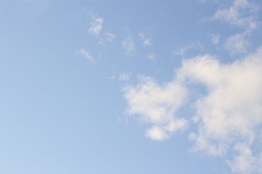 Blue bright summer sky with soft light white clouds on sunny warm day in Madrid Spain horizontal rectangular photo.