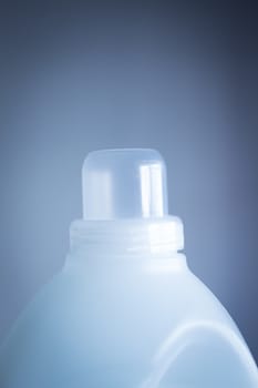 Bottle of washing liquid detergent fabric softener close-up product pack shot studio isolated on plain blue background with vignette effect. 