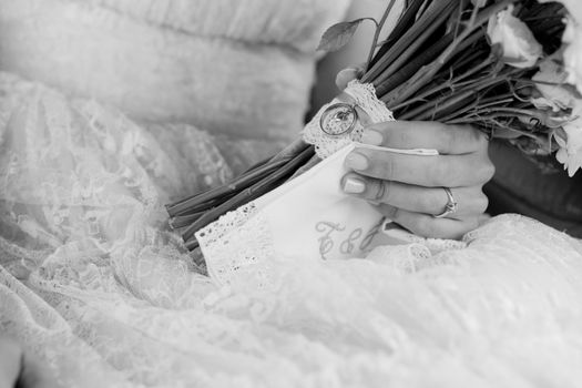 Black and white photo of wedding marriage bouquet in hands of bride.