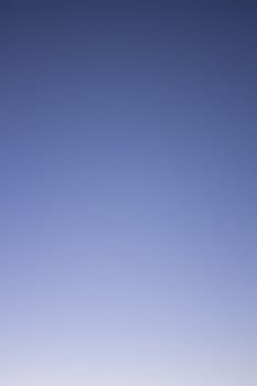 Light blue and dark blue sky cloudless sunny warm day vertical rectangular photo. 