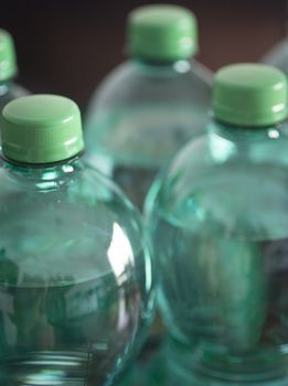 Large bottles of 1.5 litre sparkling mineral drinking water in green tone shot from above close-up color photo. 