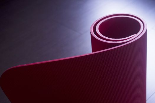 Red fitness, yoga and pilates foam mats in sports aerobics gymnasium. Artistic photo. 