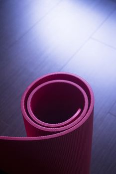 Red fitness, yoga and pilates foam mats in sports aerobics gymnasium. Artistic photo. 