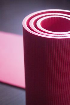 Red fitness, yoga and pilates foam mats in sports aerobics gymnasium. Artistic photo. 