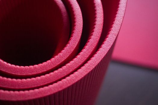 Red fitness, yoga and pilates foam mats in sports aerobics gymnasium. Artistic photo. 