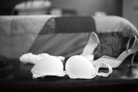 Wedding bridal garter belt, bra lingerie and white shoes in Madrid Spain. Black and white photo with shallow depth of focus. 