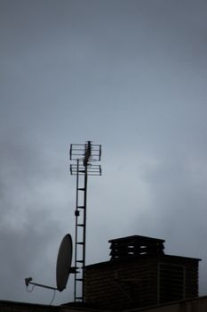 TV arial television antenna and satellite dish on roof of a building and blue sky in Madrid Spain. 