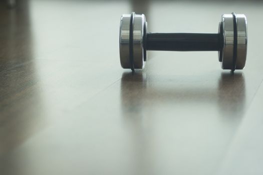 Dumbbell gym metal weights on wooden floor in exercise room in gym health club.