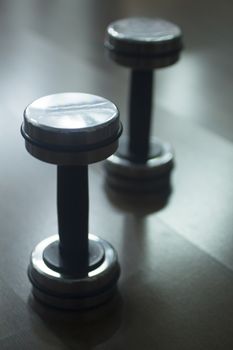 Dumbbell gym metal weights on wooden floor in exercise room in gym health club.