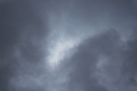 Blue bright summer sky with gray rain clouds on windy Autumn day in Madrid Spain vertical rectangular photo.