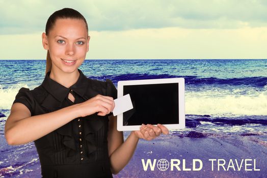 Beautiful businesswoman holding blank tablet PC and blank business card in front of PC screen. Inscription World Travel. Seascape whith tidal waves as backdrop