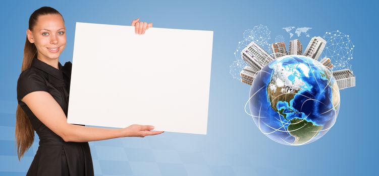 Beautiful businesswoman holding blank paper sheet. Beside is miniature Earth with houses on it and surrounded by conventional communication lines and other virtual elements. Elements of this image furnished by NASA