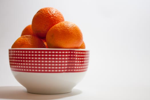 Tangerines in a bowl on the white background.