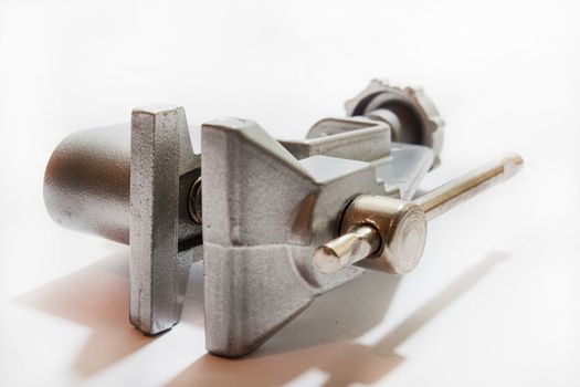 Silver colored metal clamps on the white table.