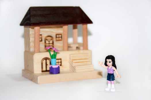 Wooden house and plastic toys on the white background.